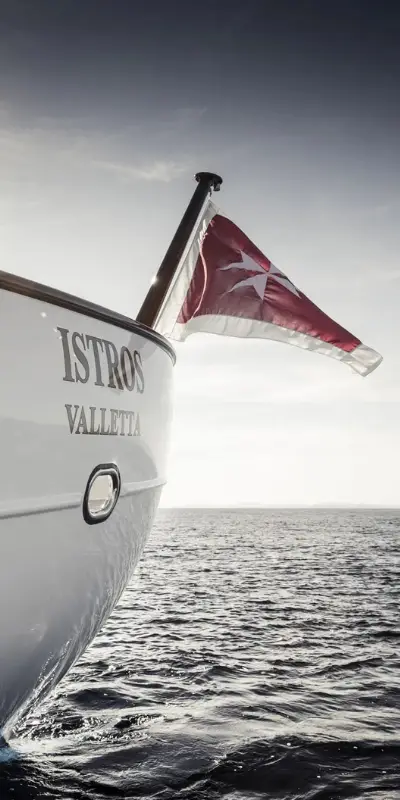 A heritage classic sailing yacht with a flag at sea