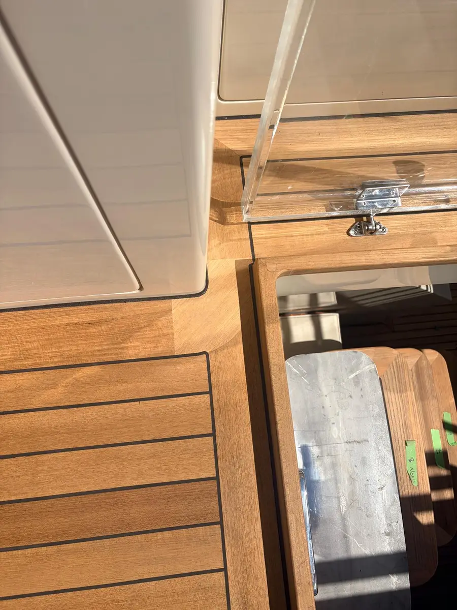 Teak plank ends and margin boards meeting an open deck hatch